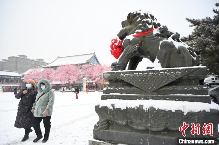 2月13日，民眾在呼和浩特市大召廣場雪中漫步?！⑽娜A 攝