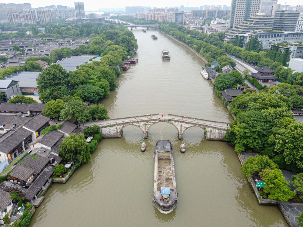 5月27日，一艘貨船駛過京杭大運(yùn)河南端標(biāo)志建筑杭州拱宸橋。(無人機(jī)照片)新華社記者江漢 攝