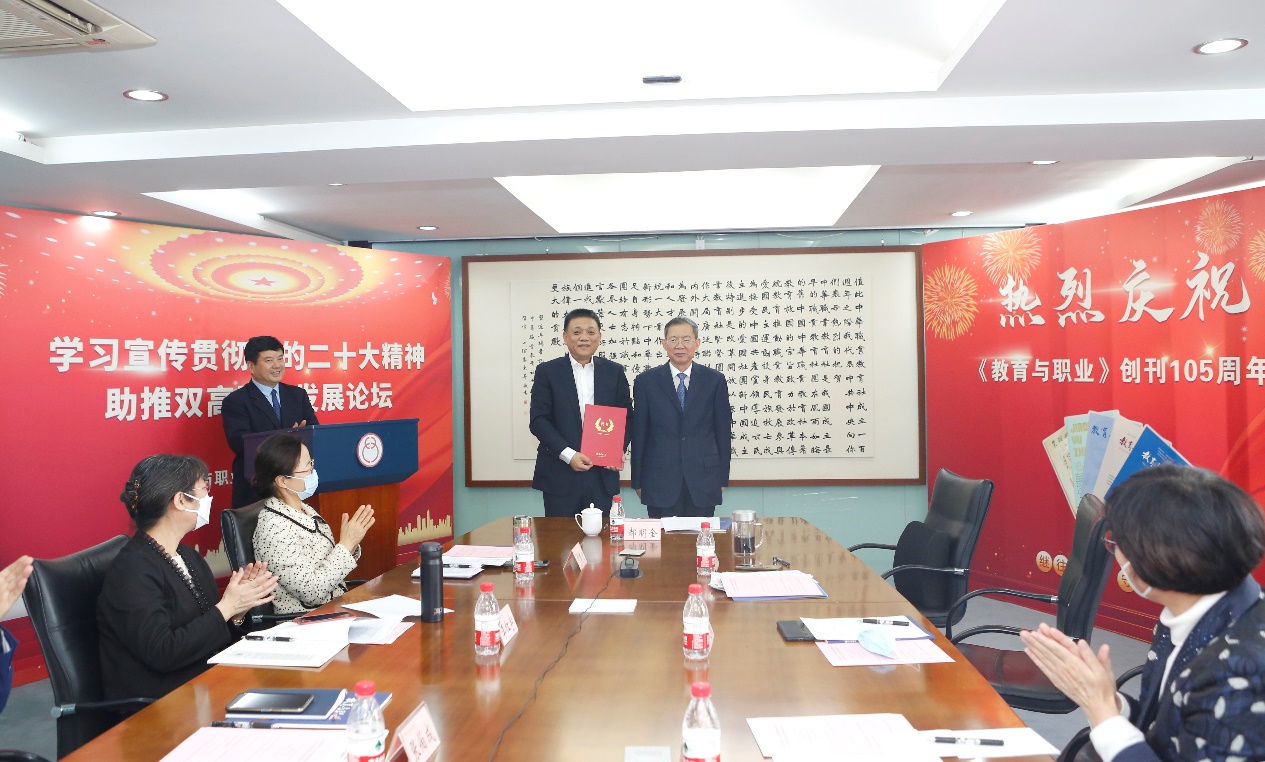 郝明金為《教育與職業(yè)》雜志編委代表陳曉明頒發(fā)聘書。中華職教社供圖