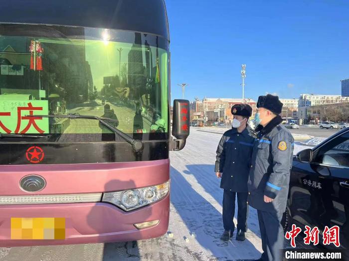 交通執(zhí)法人員檢查客運車輛手續(xù)。　黑龍江省交通運輸廳供圖