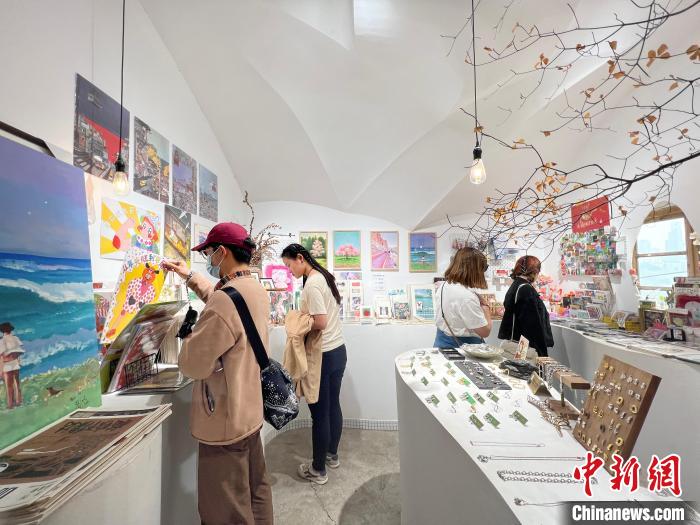 圖為藝術(shù)品商店內(nèi)，顧客挑選插畫作品。　鐘旖 攝