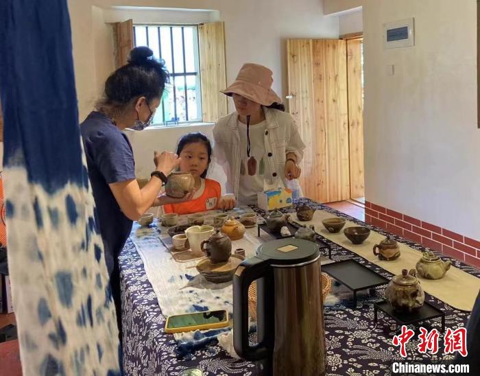 圖為：游客正在咨詢臺灣柴燒作品?！∪~秋云 攝