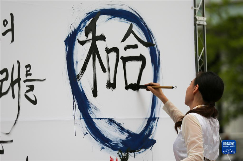 5月30日，在韓國(guó)首爾舉辦的“中日韓合作之日”慶?；顒?dòng)中，表演者進(jìn)行中日韓精神——2023年度漢字“和合”書(shū)法表演。新華社記者 王益亮 攝