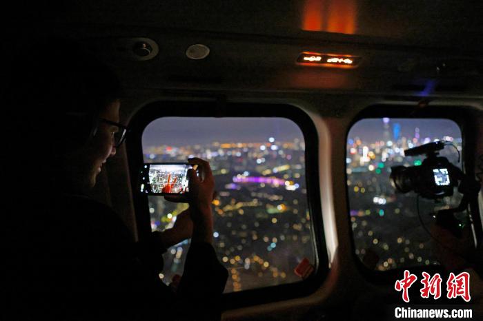 6月3日晚，游客乘坐上海新空直升機(jī)有限公司直升機(jī)開啟鳥瞰黃浦江空中圓夢之旅，并用手機(jī)拍攝城市夜景?！∫罅⑶?攝