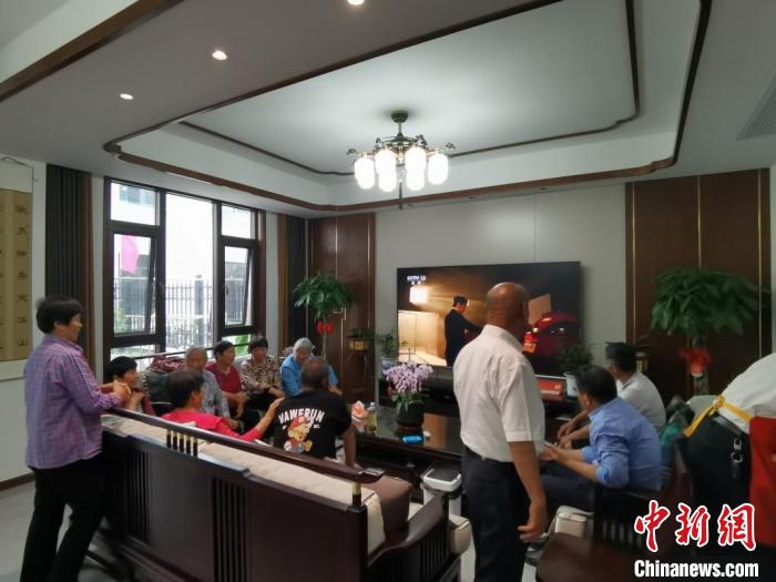 親友們集中在費(fèi)俊龍家中觀看返程的視頻?！＄娚?攝
