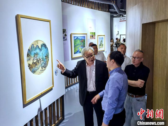 海峽兩岸藝術(shù)家畫展上，藝術(shù)家進(jìn)行藝術(shù)交流?！「毒窜?攝
