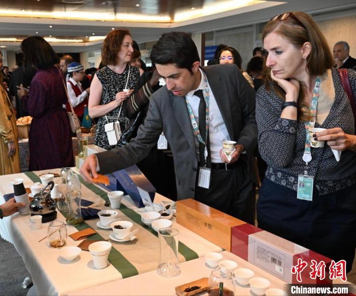 現(xiàn)場觀眾觀看中國展臺(tái)茶藝表演、了解茶文化。　靖樹 攝