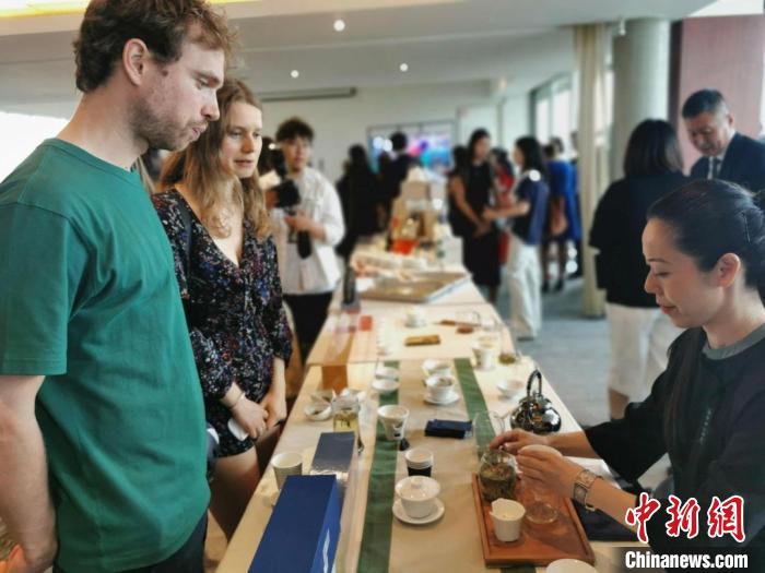 現(xiàn)場觀眾觀看中國展臺(tái)茶藝表演、了解茶文化。　靖樹 攝