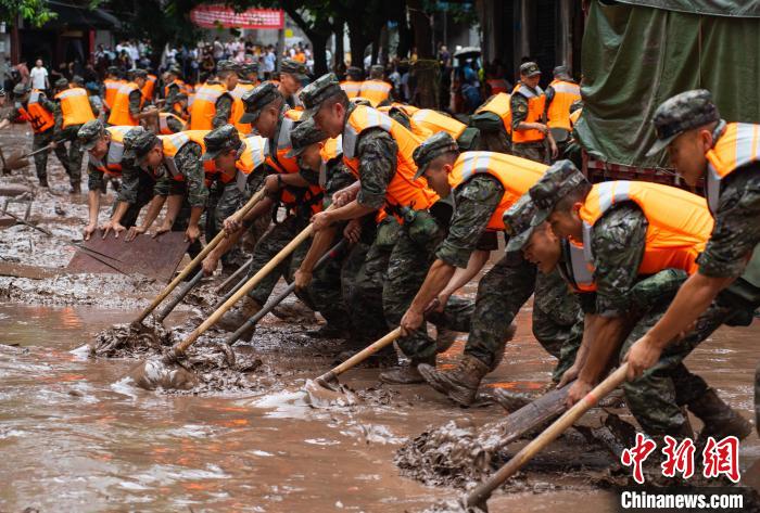 7月4日，萬(wàn)州區(qū)五橋街道，武警官兵清理街道上的淤泥。　冉孟軍 攝
