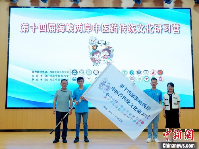共青團福建省委副書記吳雪(右一)、福建中醫(yī)藥大學黨委副書記林羽(左一)為兩岸學生代表頒授營旗?！≡S燁婷 攝