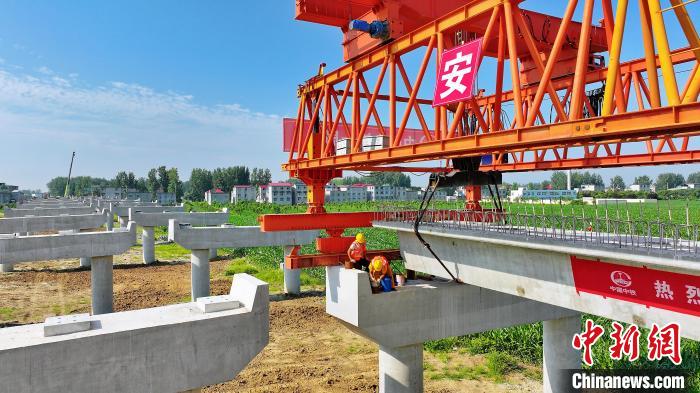 長25米重80噸的箱梁平穩(wěn)、精準(zhǔn)地落在S314分離式立交橋25號和26號墩上。　劉玉才 攝