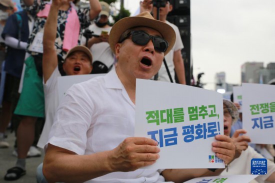 7月22日，在韓國(guó)首爾，人們手舉標(biāo)語參與反戰(zhàn)游行。新華社發(fā)（楊暢 攝）