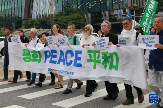 7月22日，在韓國(guó)首爾，人們手舉標(biāo)語參與反戰(zhàn)游行。新華社發(fā)（楊暢 攝）