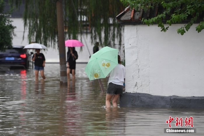 7月31日，市民行走在雨中的北京房山區(qū)瓦窯頭村。北京市氣象臺(tái)當(dāng)日10時(shí)發(fā)布分區(qū)域暴雨紅色預(yù)警信號。北京市水文總站發(fā)布洪水紅色預(yù)警，預(yù)計(jì)當(dāng)日12時(shí)至14時(shí)，房山區(qū)大石河流域?qū)⒊霈F(xiàn)紅色預(yù)警標(biāo)準(zhǔn)洪水。<a target='_blank' href='/'><p  align=