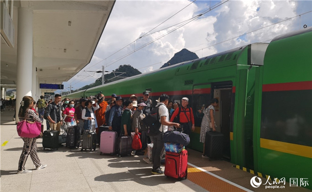 乘坐中老鐵路國際旅客列車的旅客在老撾瑯勃拉邦站排隊(duì)上車。人民網(wǎng)記者 杜明明攝