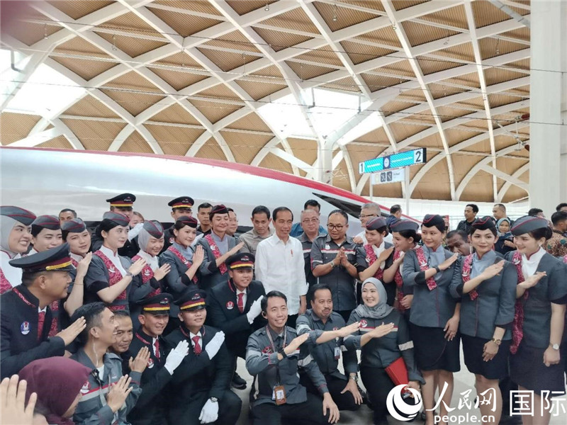 印尼總統(tǒng)佐科與雅萬高鐵乘務(wù)員及中印尼嘉賓合影。人民網(wǎng)記者 李培松攝