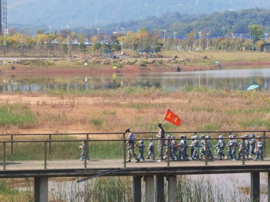 　　10月24日，秋游的幼兒園小朋友在老師帶領(lǐng)下走在清水塘公園里的木橋上。本報(bào)記者 常雯宜攝