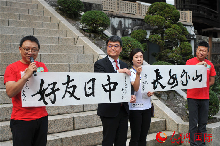 東京中國文化中心主任羅玉泉展示其為本次活動書寫的題詞“中日友好，山高水長”。人民網(wǎng) 蔣曉辰攝