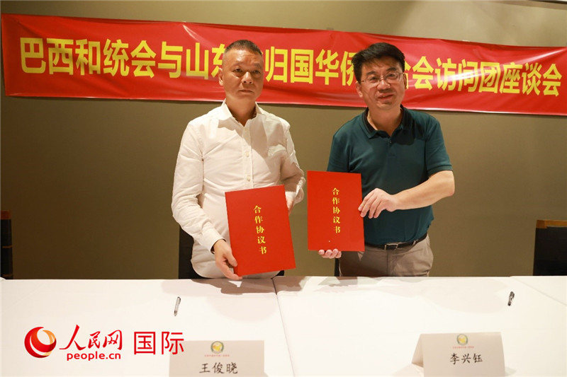 中國(guó)僑聯(lián)副主席、山東省僑聯(lián)主席李興鈺（右）與巴西和統(tǒng)會(huì)會(huì)長(zhǎng)王俊曉簽署合作協(xié)議書。人民網(wǎng)記者 陳海琪攝