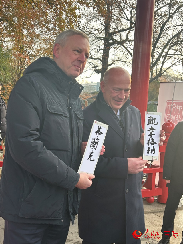柏林市長韋格納（右）、動(dòng)物園監(jiān)事會(huì)主席布魯克曼（左）手持中國文化中心工作人員現(xiàn)場手書的中文名字。人民網(wǎng)記者 徐馨攝