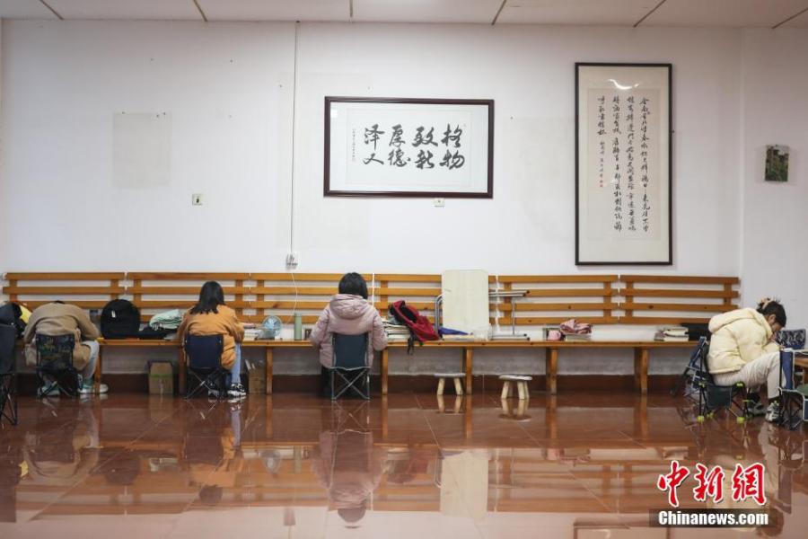 資料圖：幾位考研學(xué)生在南昌大學(xué)教學(xué)樓的公共空間復(fù)習(xí)備考。劉力鑫 攝