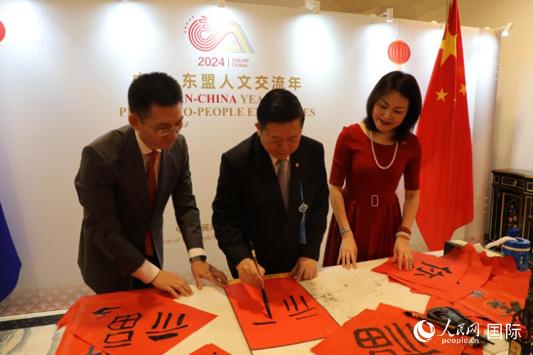 東盟秘書長高金洪（中）在活動現(xiàn)場寫福字。人民網(wǎng)記者曹師韻攝
