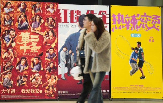 這是2月17日，在沈陽一家影院，觀眾從海報(bào)前經(jīng)過。新華社記者李鋼攝