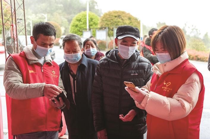 長沙縣黨員志愿者正在幫助參與核酸檢測的群眾掃描“場所碼”。劉思源 攝