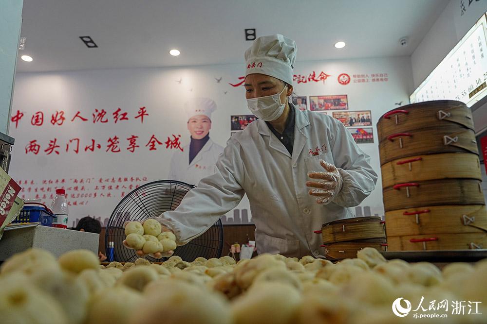 3月31日，在浙江省嵊州市甘霖鎮(zhèn)，嵊州小吃從業(yè)者沈紅平把蒸熟的小籠包晾涼，打包冷藏售賣。人民網(wǎng) 章勇濤攝
