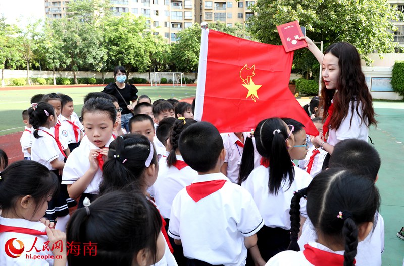 老師向少先隊(duì)員展示隊(duì)旗。人民網(wǎng) 符武平攝