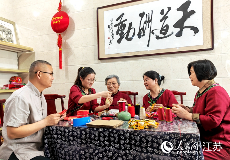 王秀英老人指導(dǎo)孫女制作香包。人民網(wǎng) 閆峰攝