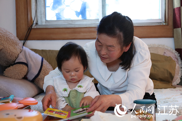 王繼蓮帶孫女看童書(shū)。人民網(wǎng) 冷金明攝