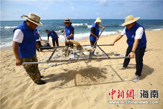 環(huán)保志愿者用篩網(wǎng)“淘”出海灘上的垃圾。