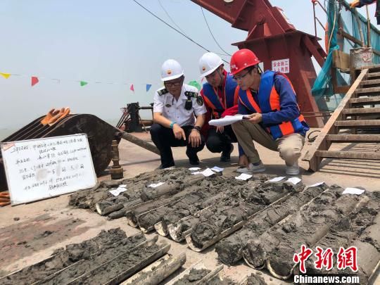 圖為勘察設(shè)計(jì)人員與海事局工作人員查看巖芯情況?！∥赫?攝