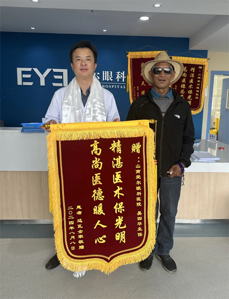 達(dá)瓦老人向吳四華（左）贈(zèng)送錦旗。受訪者供圖