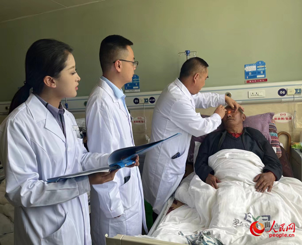 董光明（左三）帶領(lǐng)醫(yī)生對(duì)患者進(jìn)行術(shù)前檢查。人民網(wǎng)記者 杜燕飛攝