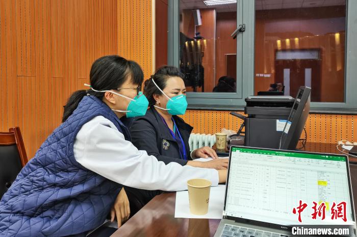 8月9日，楊蘇喬(左)在拉薩方艙醫(yī)院指揮部讀取艙內(nèi)患者胸部CT?！∈茉L者供圖