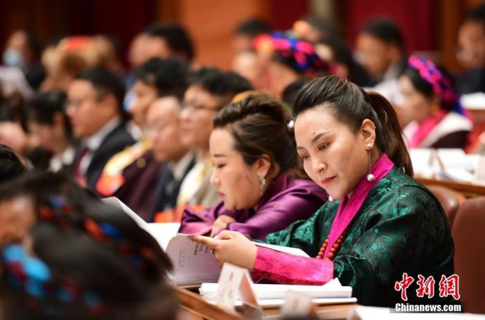 1月5日，次旦卓嘎(右一)在拉薩參加西藏自治區(qū)第十一屆人民代表大會(huì)第五次會(huì)議第二次全體會(huì)議。西藏自治區(qū)人大代表次旦卓嘎來自日喀則市定日縣，定日縣被稱為“洛諧故鄉(xiāng)”，作為西藏民間歌舞，洛諧已被列入中國國家非物質(zhì)文化遺產(chǎn)項(xiàng)目名錄，這是集歌、舞、樂、彈唱于一體的綜合藝術(shù)形式。參加完西藏2022年新年音樂會(huì)的次旦卓嘎告訴記者，每年參加的基層演出可達(dá)80場(chǎng)，“我希望用最純粹的方式，把最好的聲音帶到西藏乃至中國的各個(gè)角落。” <a target='_blank' href='/'><p  align=