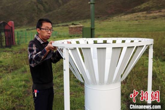 圖為班瑪縣氣象局工作人員在維護藏雪茶基地氣候站。青海省氣象局供圖