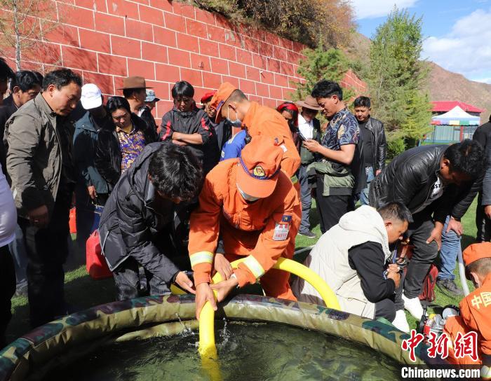 圖為森林消防員為護林員講解滅火裝備的使用方法?！〔际猩窒乐ш?供圖