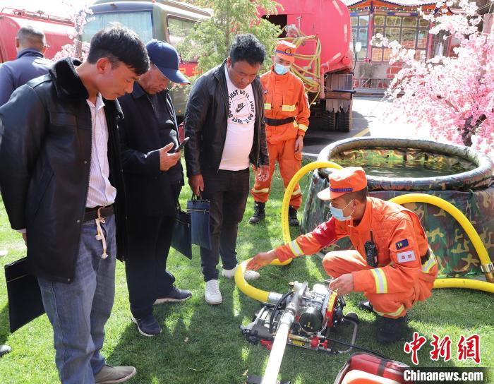 圖為森林消防員為護林員講解滅火裝備的使用方法。　昌都市森林消防支隊 供圖