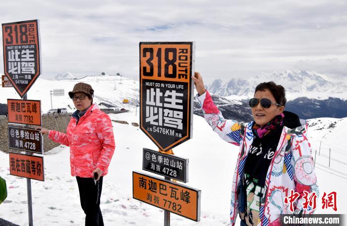 圖為5月14日，西藏林芝色季拉山觀景臺，游客與南迦巴瓦峰合影?！±盍?攝
