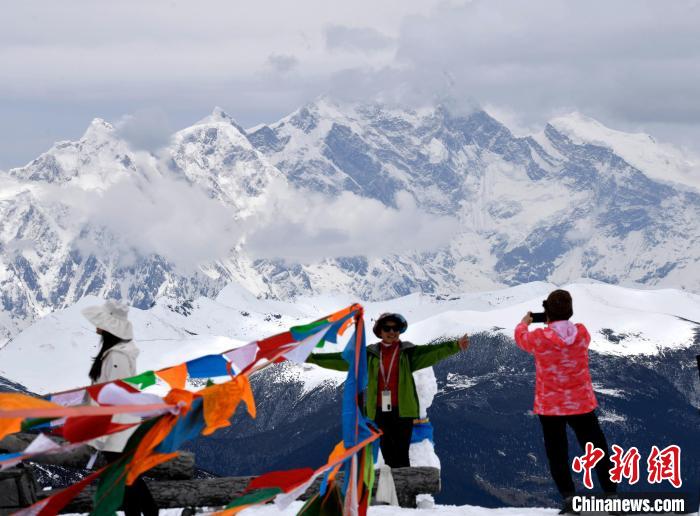 圖為5月14日，西藏林芝色季拉山觀景臺，游客與南迦巴瓦峰合影。　李林 攝
