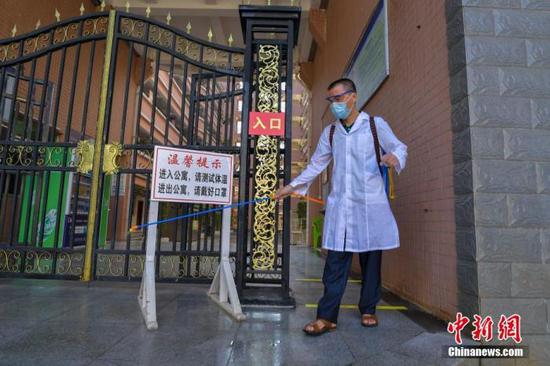 資料圖：?？诮?jīng)濟學院的工作人員在學生宿舍樓入口消毒。 中新社記者 駱云飛 攝