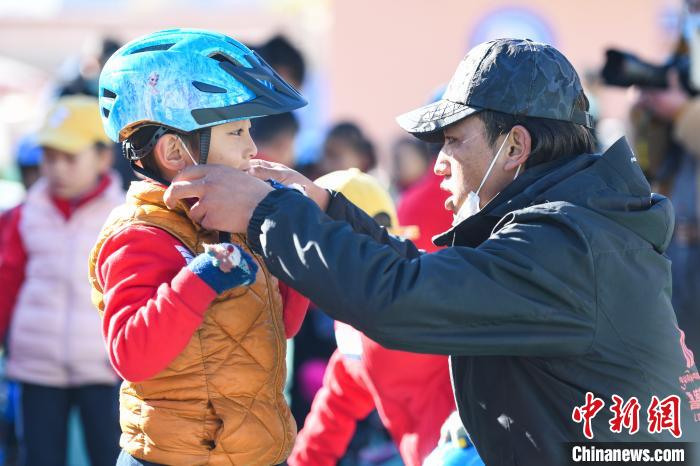 圖為拉薩市實驗幼兒園孩子在教練的幫助下穿戴頭盔?！『闻罾?攝