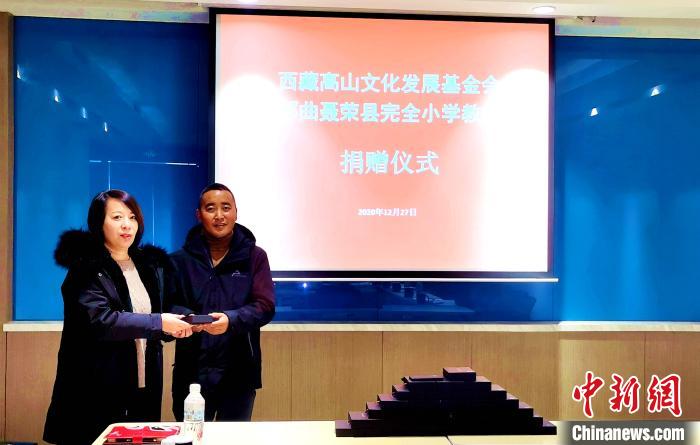 圖為西藏高山文化發(fā)展基金會理事長溫麗向聶榮縣完全小學(xué)負責(zé)人捐助儀器?！∮谫e 攝