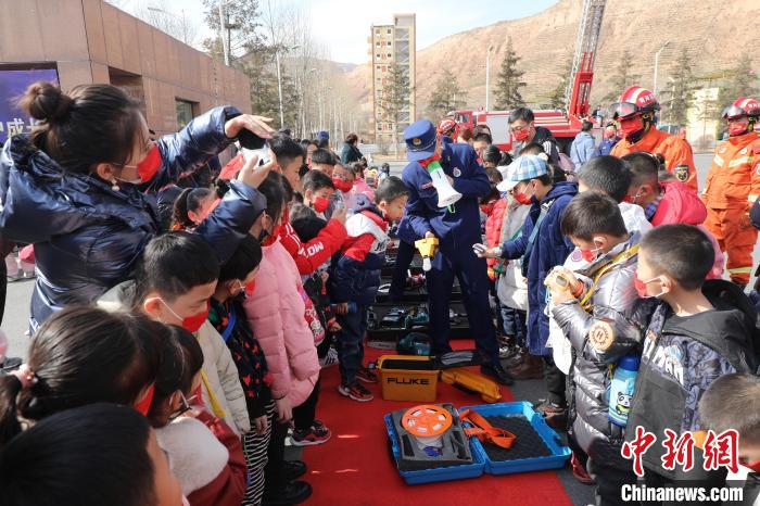 圖為小朋友們聽消防員講解消防器材?！铨埥?攝