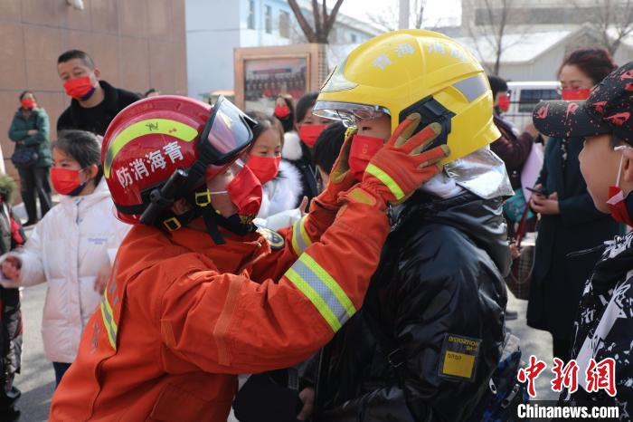 圖為小朋友體驗(yàn)試穿消防滅火防護(hù)服。　楊龍建 攝
