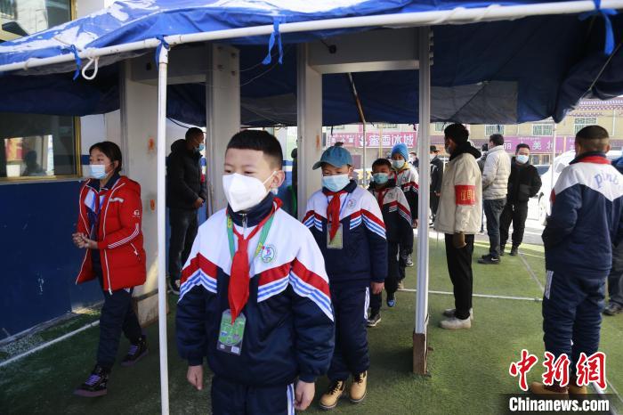 圖為學生測量體溫后進入校園?！●R銘言 攝