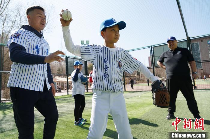 圖為教練指導(dǎo)小棒球手?jǐn)S球技術(shù)?！●R銘言 攝
